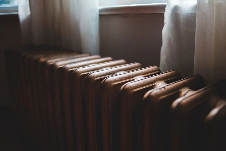 Cast-iron heating radiator beside a window
